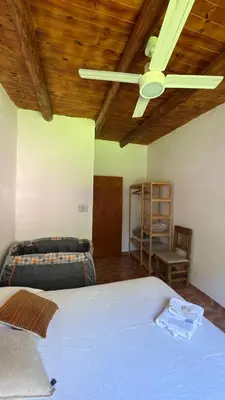 a bedroom with two beds and a ceiling fan at LA FACUNDA in San Francisco del Monte de Oro