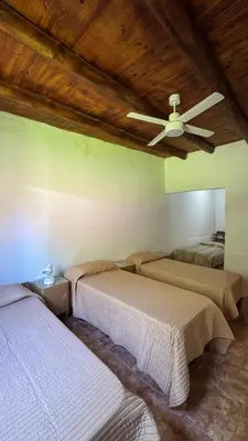a bedroom with two beds and a ceiling fan at LA FACUNDA in San Francisco del Monte de Oro