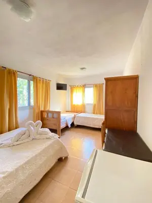 a bedroom with two beds and two windows at Posada D`Lua in Villa Carlos Paz