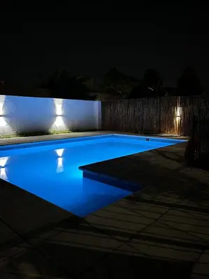 a swimming pool lit up at night with lights at Posada D`Lua in Villa Carlos Paz