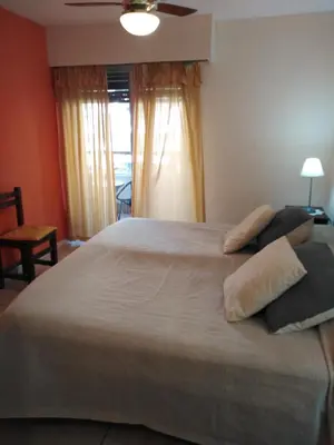a bedroom with a large bed with pillows on it at Amplio departamento en Nueva Cordoba - Bv Chacabuco in Cordoba