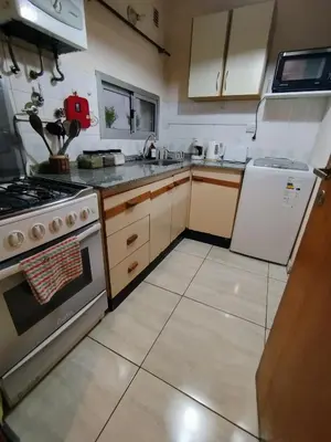 a kitchen with a stove and a refrigerator at Amplio departamento en Nueva Cordoba - Bv Chacabuco in Cordoba