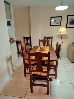 a dining room with a wooden table and chairs at Amplio departamento en Nueva Cordoba - Bv Chacabuco in Cordoba