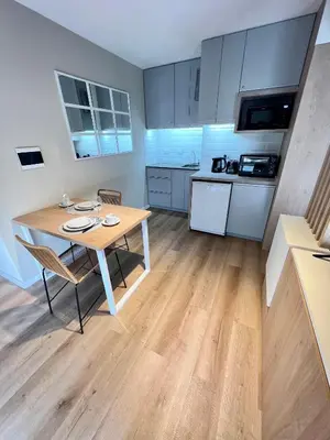 a kitchen with a wooden table and a dining room at Estudio - apartamento cómodo y acogedor SS1 in Cordoba