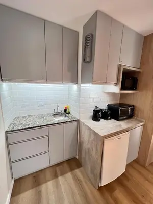 a small kitchen with white cabinets and a sink at Estudio - apartamento cómodo y acogedor SS1 in Cordoba