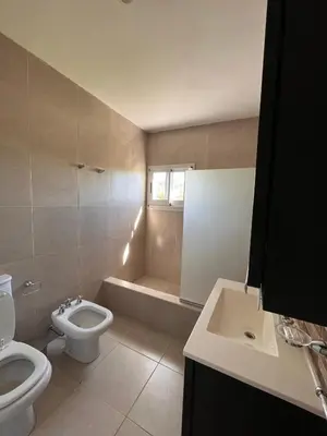 a bathroom with a toilet and a tub and a sink at La Americana, casa entre sierras in Luján