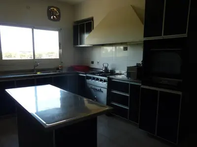 a kitchen with black cabinets and a counter top at La Americana, casa entre sierras in Luján