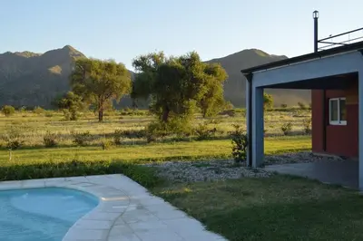a house with a swimming pool next to a field at La Americana, casa entre sierras in Luján