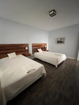 two beds in a hotel room with white sheets at La Americana, casa entre sierras in Luján