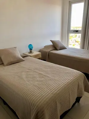 two beds in a room with a window at Güemes Premium, 2 dorm con Vista a las Sierras ALOHA #2 in Cordoba