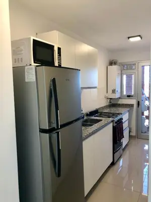 a kitchen with a refrigerator and a microwave at Güemes Premium, 2 dorm con Vista a las Sierras ALOHA #2 in Cordoba