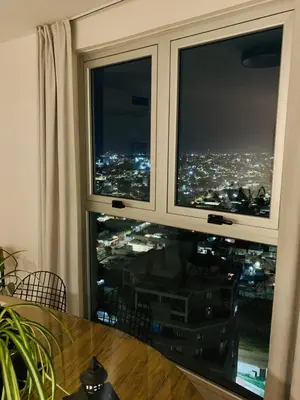 a window with a view of a city at night at Güemes Premium, 2 dorm con Vista a las Sierras ALOHA #2 in Cordoba
