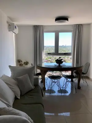 a living room with a table and a couch at Güemes Premium, 2 dorm con Vista a las Sierras ALOHA #2 in Cordoba