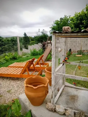 a garden with two large pots and a wooden door at ENCANTO SERRANO in Villa Carlos Paz