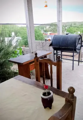 a table and chairs on a patio with a grill at ENCANTO SERRANO in Villa Carlos Paz