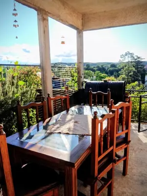 a wooden table and chairs on a porch with a view at ENCANTO SERRANO in Villa Carlos Paz