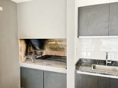 a kitchen with a stove top oven in a kitchen at HABITAT Departamentos in Villa Carlos Paz