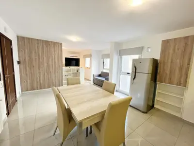 a kitchen with a wooden table and a refrigerator at HABITAT Departamentos in Villa Carlos Paz