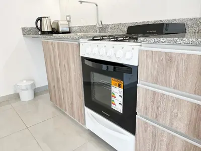 a kitchen with a black and white stove top oven at HABITAT Departamentos in Villa Carlos Paz