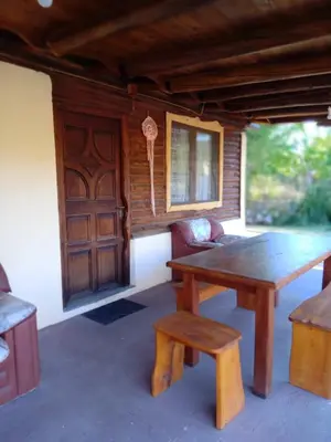 a wooden table and bench in a room with a door at Peumayen Cabañas in Villa de Las Rosas