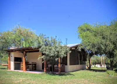a small house in a field with trees at Peumayen Cabañas in Villa de Las Rosas