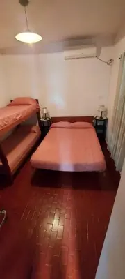 two beds in a room with a brick floor at Castillo Del Lago - Carlos Paz - D16 in Villa Carlos Paz