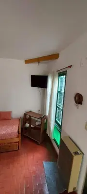 a room with a bed and a television and a window at Castillo Del Lago - Carlos Paz - D16 in Villa Carlos Paz