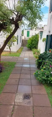 a sidewalk in front of a building with a tree at Castillo Del Lago - Carlos Paz - D16 in Villa Carlos Paz