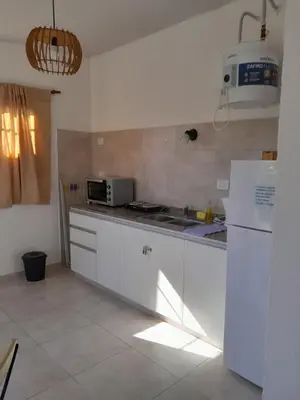 a kitchen with white cabinets and a white refrigerator at Complejo Yarken in Potrero de Garay