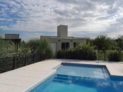 a swimming pool in front of a house at Complejo Yarken in Potrero de Garay