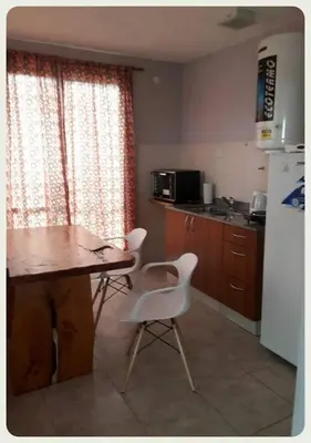 a kitchen with a table and two chairs and a refrigerator at Complejo Yarken in Potrero de Garay