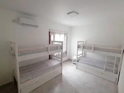 two bunk beds in a white room with a window at Casa hasta 10 personas. in Villa Rumipal