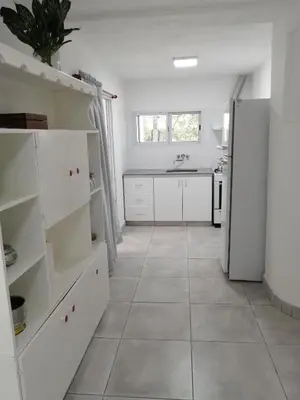 a kitchen with white cabinets and a tile floor at Casa hasta 10 personas. in Villa Rumipal