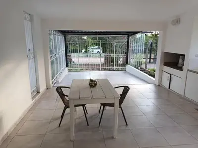 a table and chairs in a living room with a balcony at Casa hasta 10 personas. in Villa Rumipal