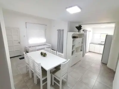 a kitchen with a white table and chairs and a refrigerator at Casa hasta 10 personas. in Villa Rumipal