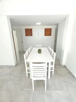 a white dining room with a white table and chairs at Casa hasta 10 personas. in Villa Rumipal