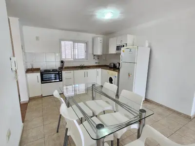 a kitchen with a glass table and white appliances at Depto La Leda in Almafuerte