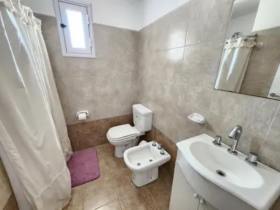 a bathroom with a white toilet and a sink at Depto La Leda in Almafuerte