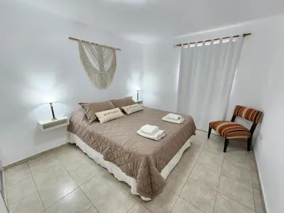a bedroom with a bed and a chair at Depto La Leda in Almafuerte