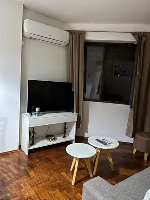 a living room with a flat screen tv and two tables at Departamento HMP en la mejor zona Cordoba in Cordoba