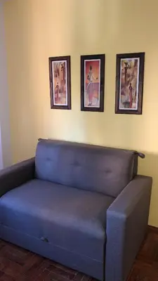 a blue couch in a room with three pictures on the wall at Departamento HMP en la mejor zona Cordoba in Cordoba