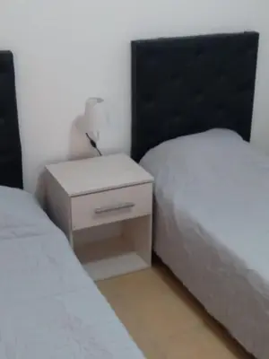 a bedroom with two twin beds and a night stand at Costanera 3 dormitorios 2 cocheras estamos a 800 metros del centro in Cordoba