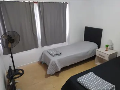 a small room with a bed and a fan at Costanera 3 dormitorios 2 cocheras estamos a 800 metros del centro in Cordoba
