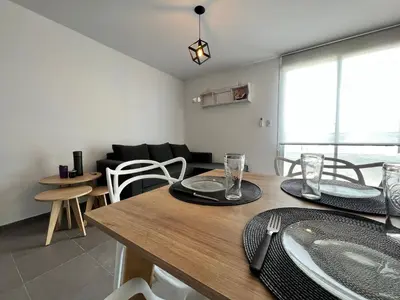 a dining room and living room with a table and chairs at “Tu lugar en Cordoba 02” Depto SADIMA Guemes in Cordoba