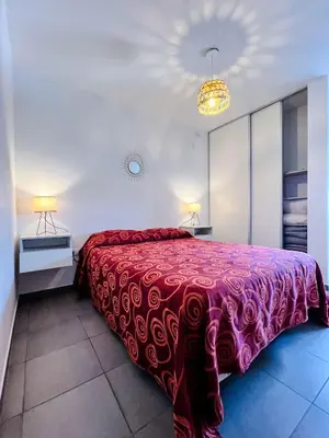 a bedroom with a large bed with a red blanket at “Tu lugar en Cordoba 02” Depto SADIMA Guemes in Cordoba