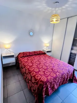 a bedroom with a red bed with two night stands at “Tu lugar en Cordoba 02” Depto SADIMA Guemes in Cordoba