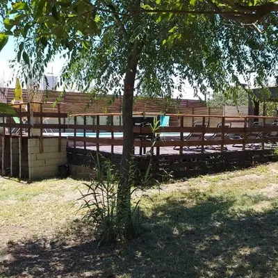 a wooden fence next to a tree in a field at CABAÑAS COPITL in Tanti