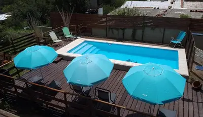 three blue umbrellas sitting next to a swimming pool at CABAÑAS COPITL in Tanti