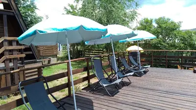 three chairs and two umbrellas on a deck at CABAÑAS COPITL in Tanti
