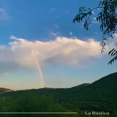 a rainbow in the sky over a mountain at La Rústica in La Bolsa